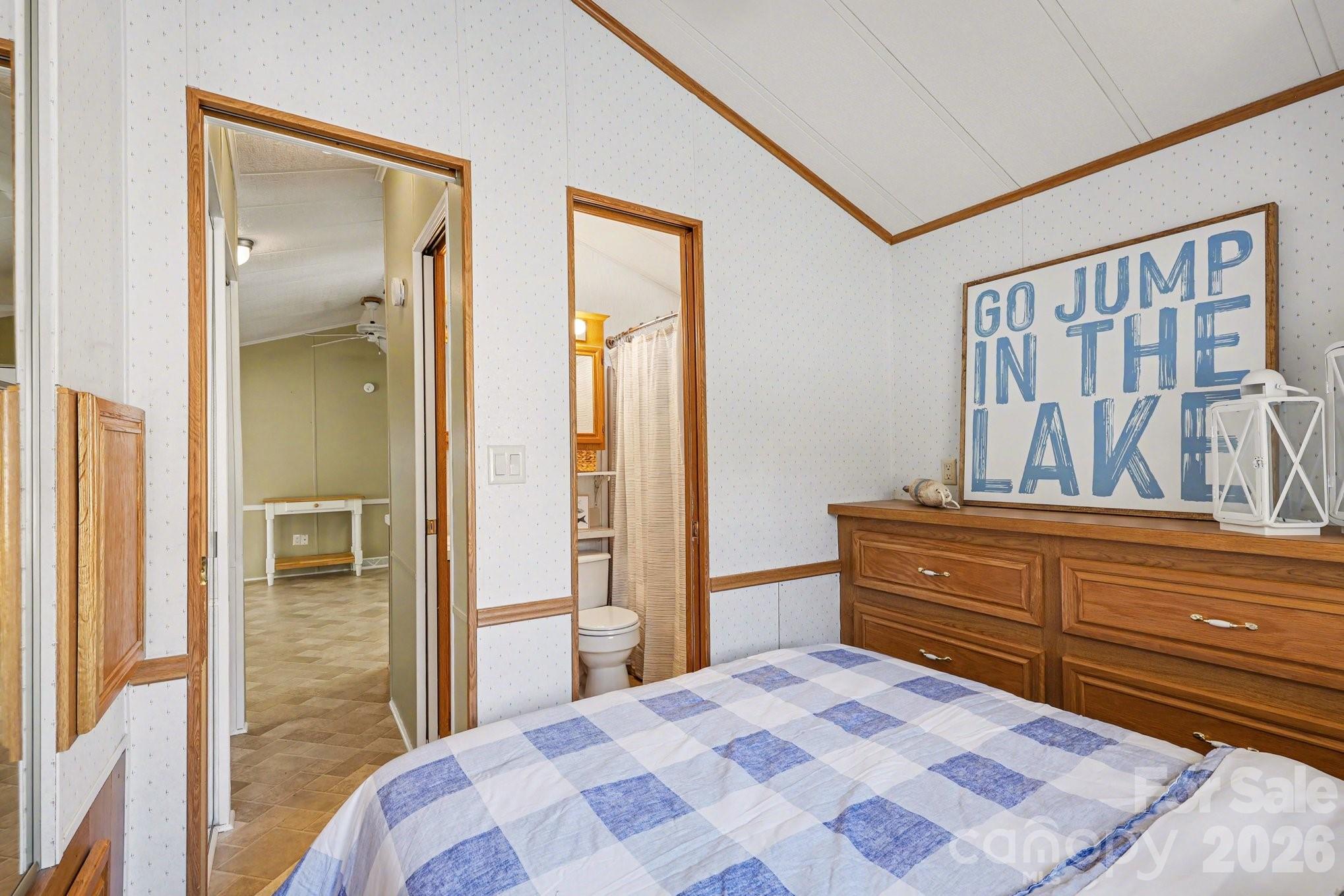 122 Maple Street New London, NC 28127 - Photo 10 of 29 a bedroom with a bed and a large mirror next to a window
