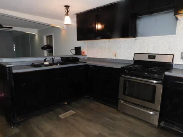 a kitchen with sink a microwave a stove and cabinets
