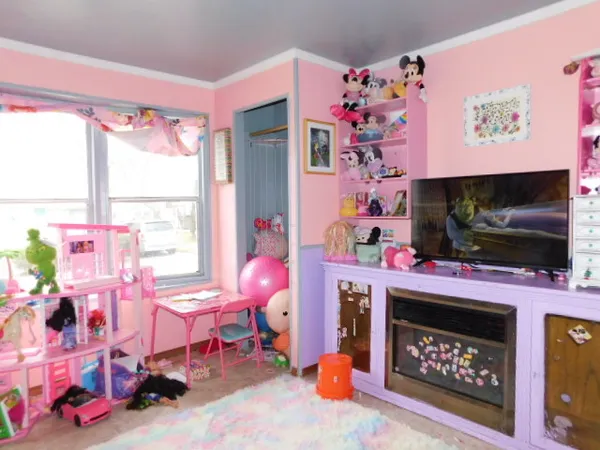 a room with furniture a flat screen tv and a fireplace with a bookshelf