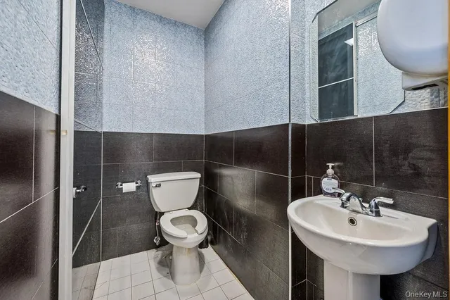 a bathroom with a sink toilet and a mirror