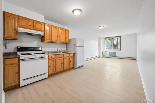 a kitchen with stainless steel appliances granite countertop a stove a sink and a refrigerator