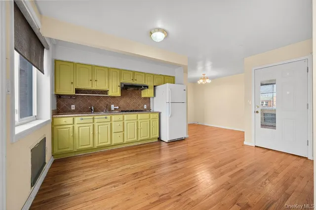 a kitchen with a refrigerator a sink and a stove top oven