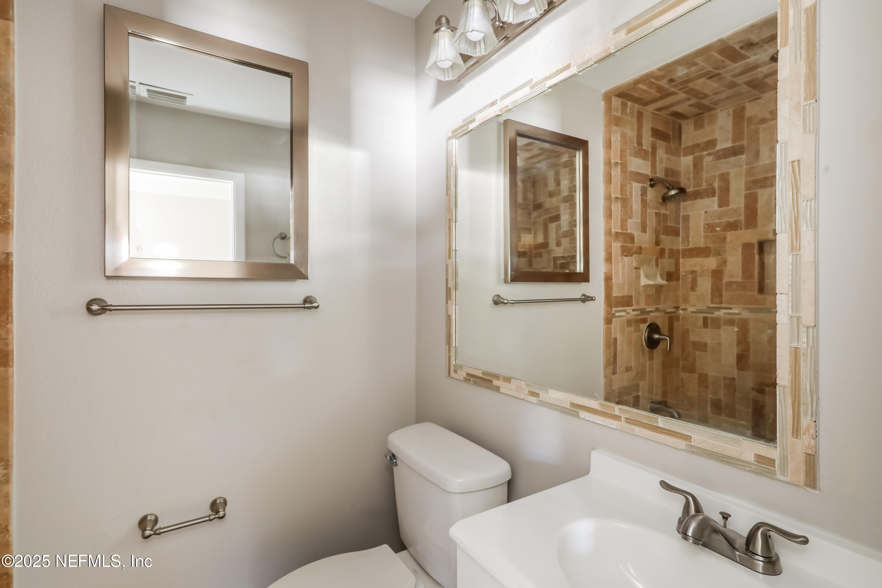 7428 Centauri Road Jacksonville, FL 32210 - Photo 13 of 15 a bathroom with a toilet a sink and mirror