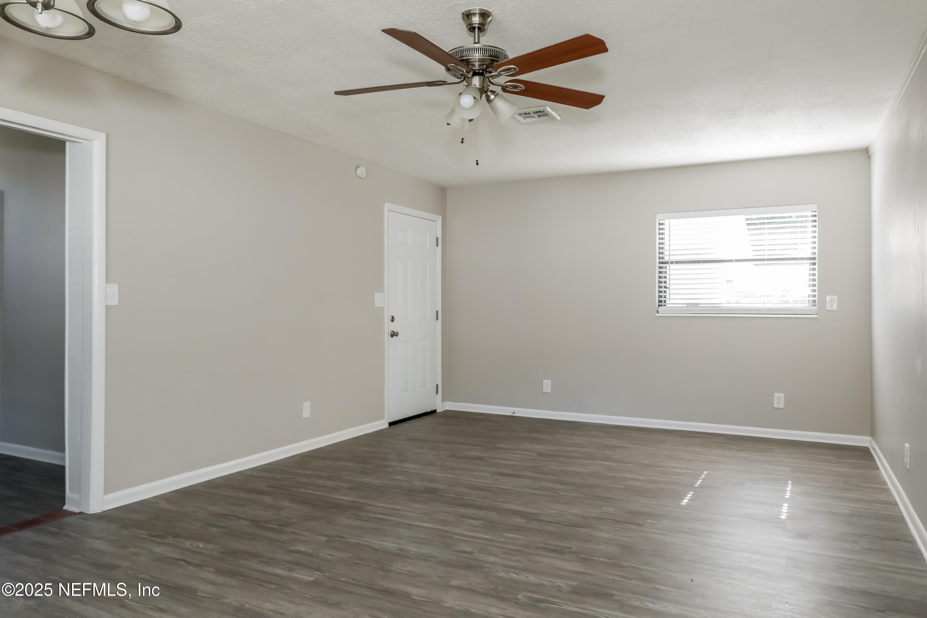 7428 Centauri Road Jacksonville, FL 32210 - Photo 4 of 15 an empty room with wooden floor and windows