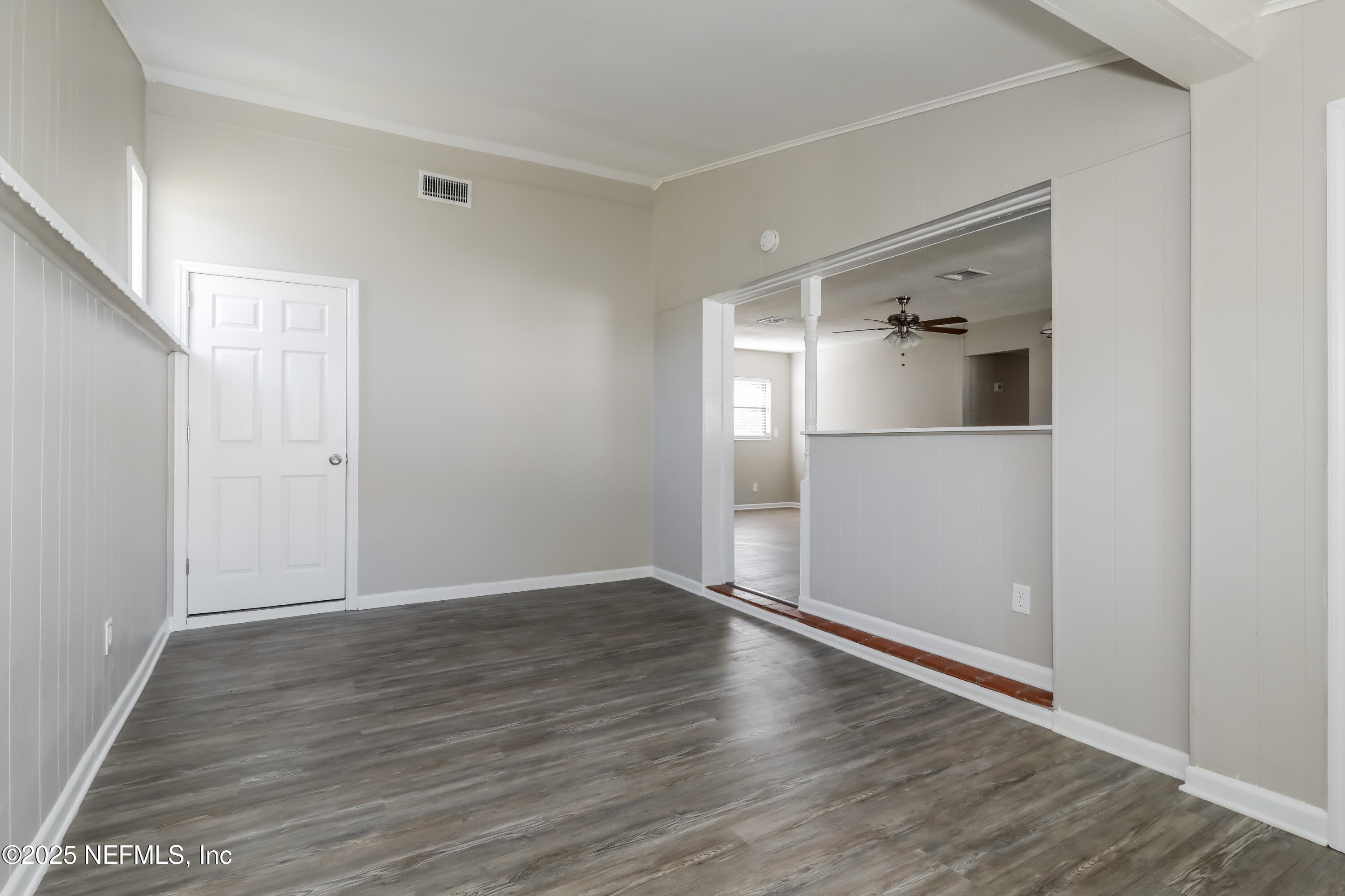 7428 Centauri Road Jacksonville, FL 32210 - Photo 5 of 15 an empty room with wooden floor and mirror