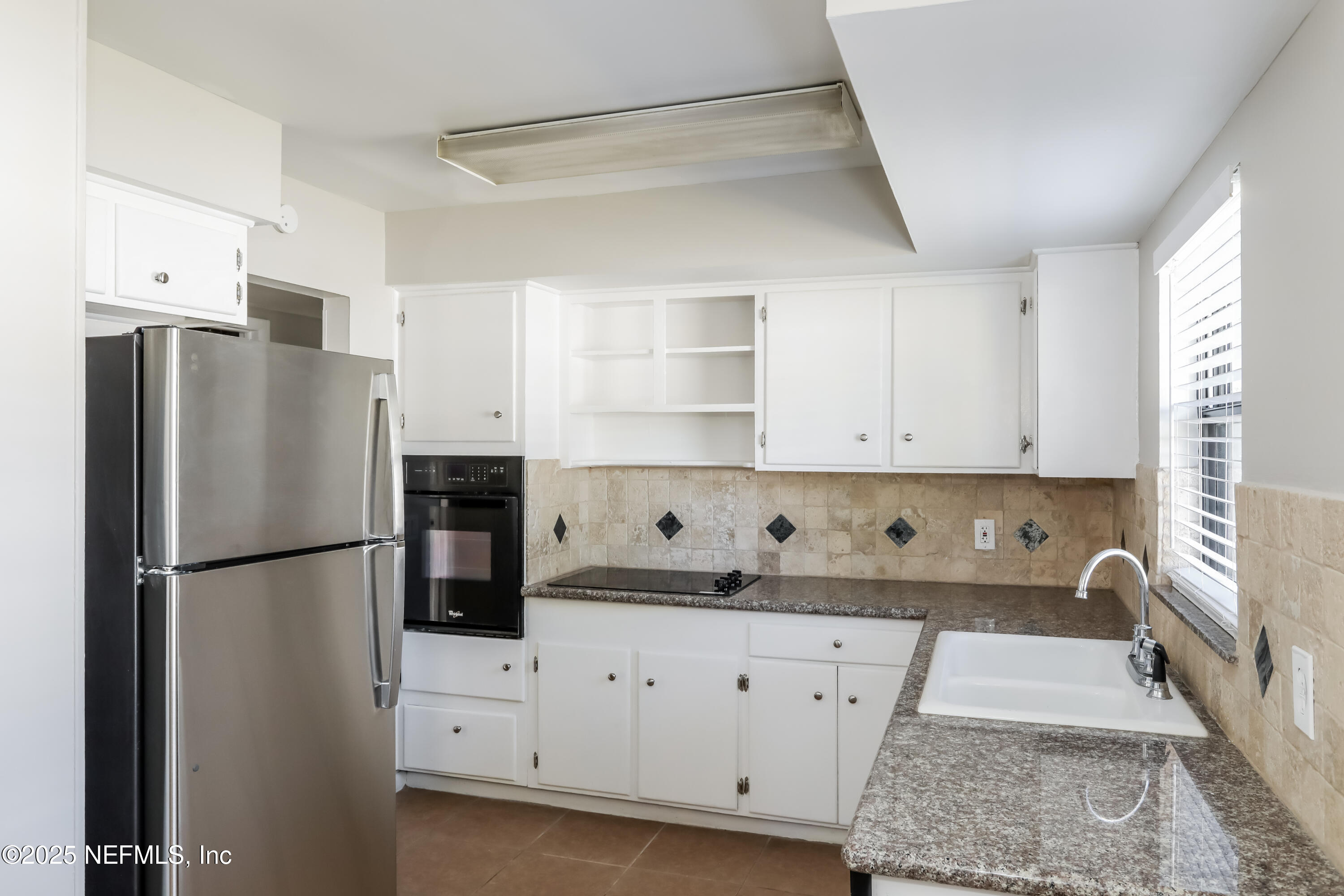 7428 Centauri Road Jacksonville, FL 32210 - Photo 7 of 15 a kitchen with cabinets a refrigerator and a stove