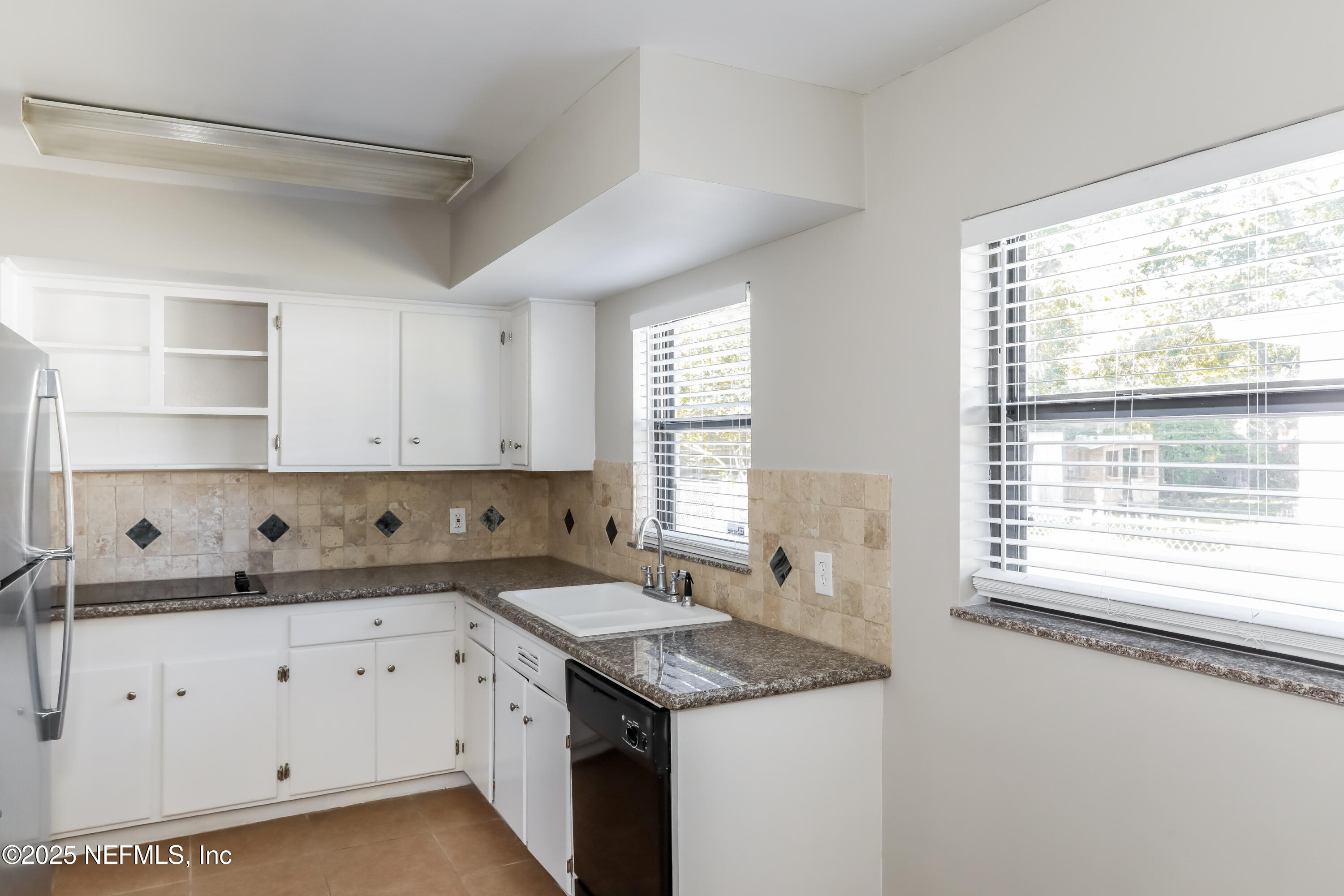 7428 Centauri Road Jacksonville, FL 32210 - Photo 8 of 15 a kitchen with granite countertop white cabinets and a window