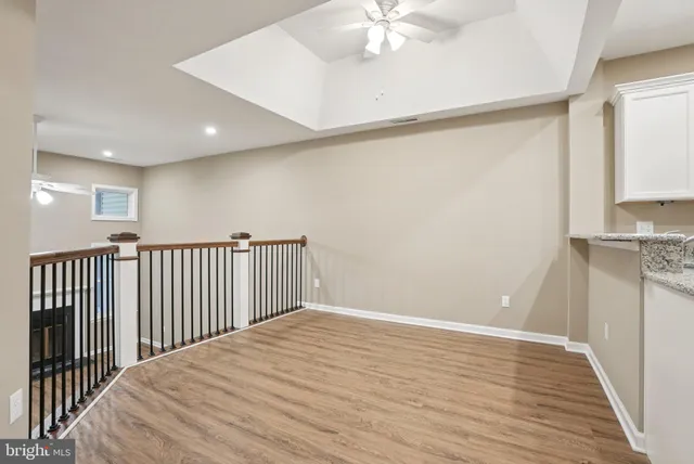 an empty room with wooden floor fireplace and windows