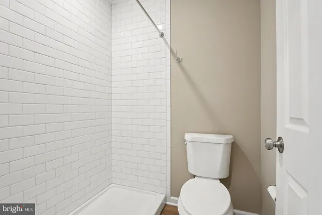 a bathroom with a toilet and a shower