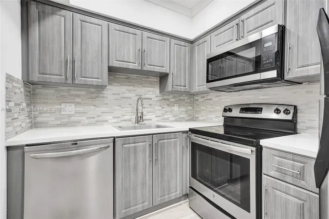a kitchen with stainless steel appliances granite countertop white cabinets a microwave and a sink
