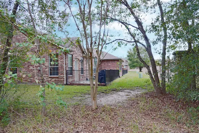 a view of a house with a yard and a tree