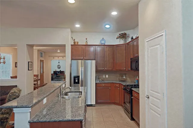 a kitchen with stainless steel appliances granite countertop a refrigerator and a sink