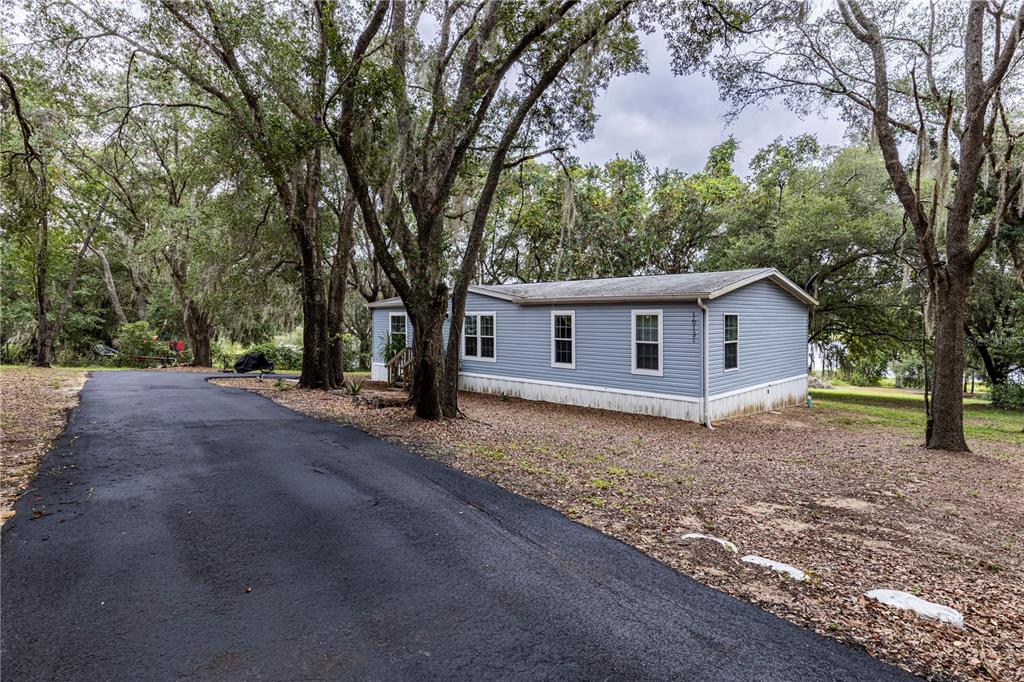10135 North Em En El Grove Road Leesburg, FL 34788 - Photo 2 of 54 a view of a house with a yard and large trees