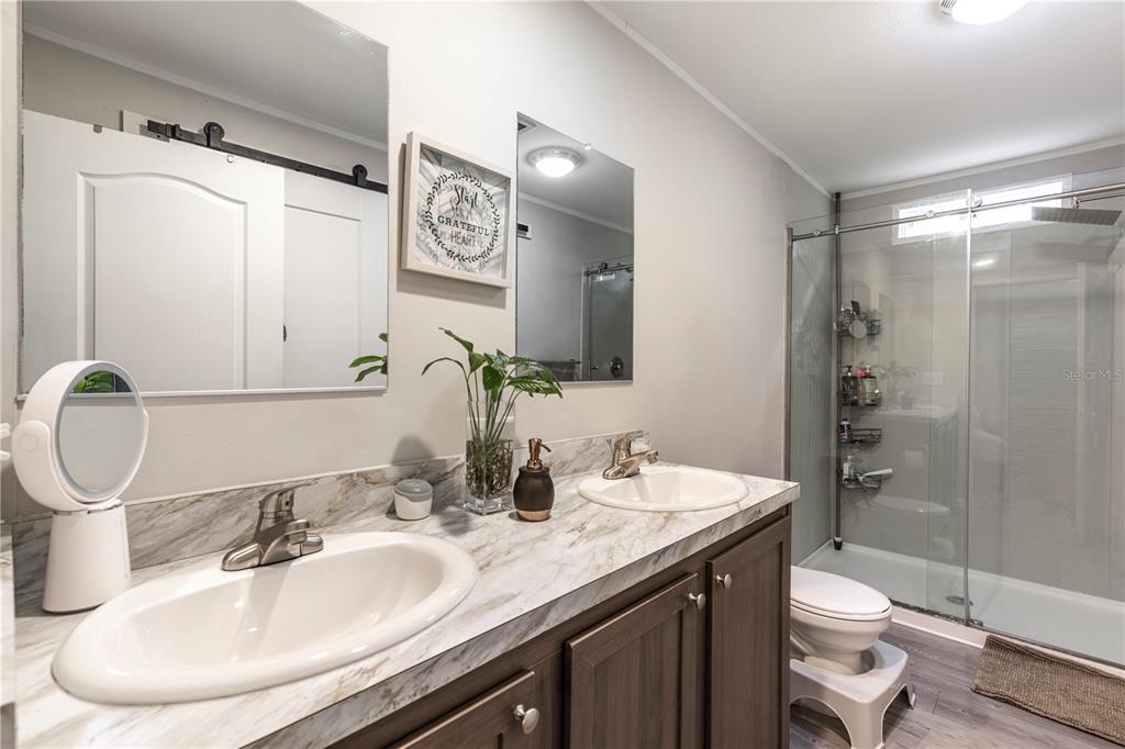 10135 North Em En El Grove Road Leesburg, FL 34788 - Photo 21 of 54 a bathroom with a granite countertop sink toilet and shower