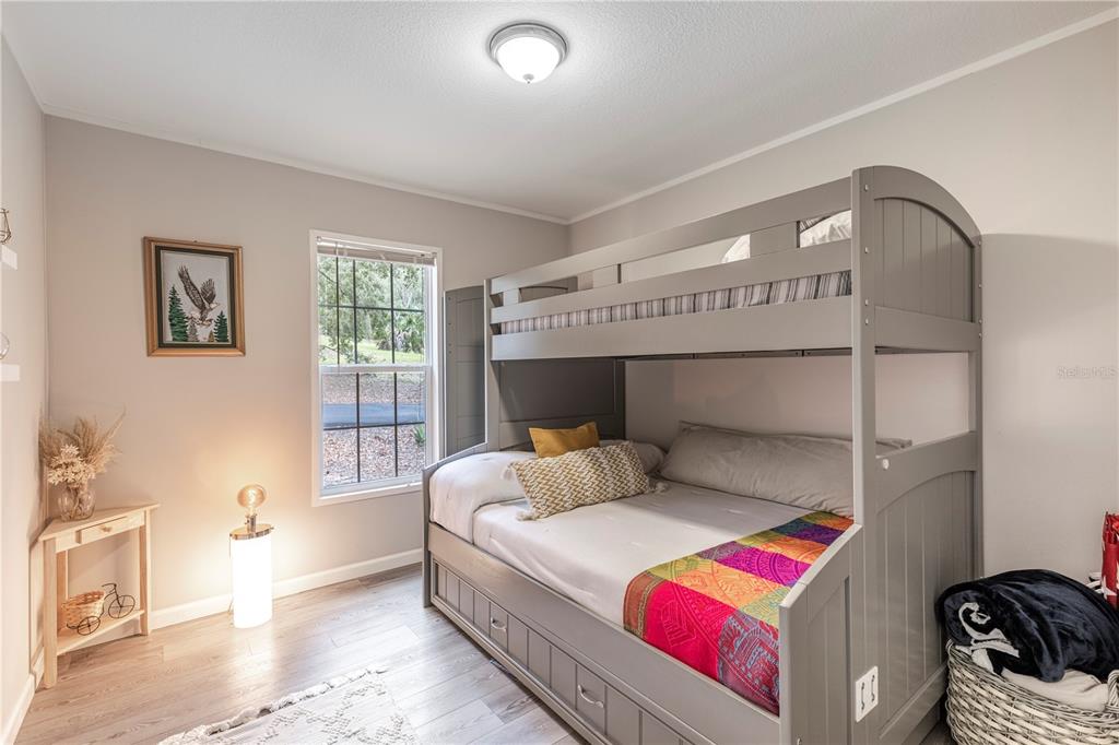 10135 North Em En El Grove Road Leesburg, FL 34788 - Photo 24 of 54 a bedroom with a bed and wooden floor