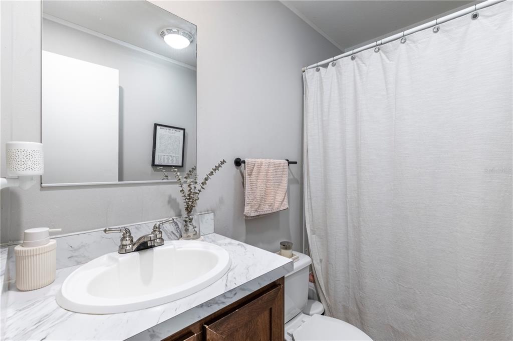 10135 North Em En El Grove Road Leesburg, FL 34788 - Photo 45 of 54 a bathroom with a sink toilet and mirror