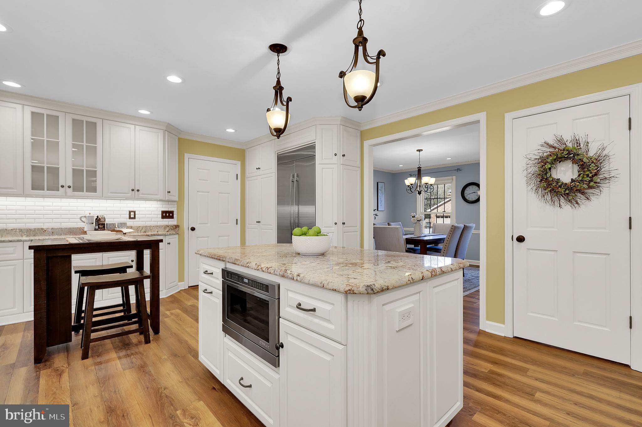 7908 River Run Court Frederick, MD 21701 - Photo 13 of 59 a kitchen with kitchen island granite countertop a white stove top oven and cabinets