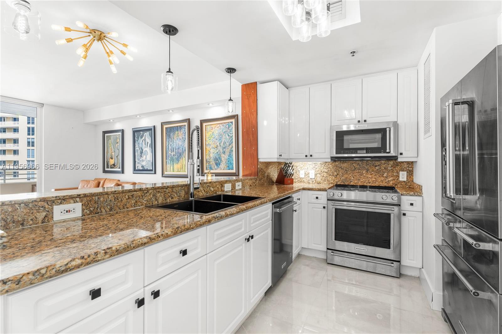 808 Brickell Key Drive, Unit 3007 Miami, FL 33131 - Photo 7 of 16 a kitchen with granite countertop a sink stainless steel appliances and white cabinets