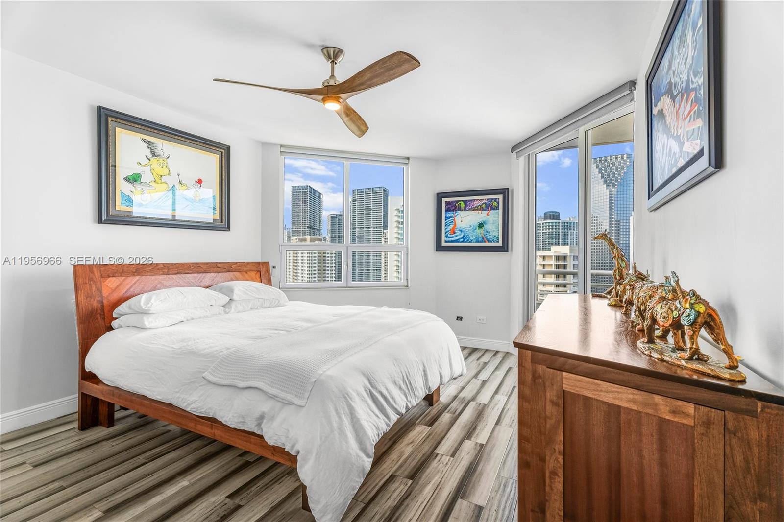 808 Brickell Key Drive, Unit 3007 Miami, FL 33131 - Photo 10 of 16 a bedroom with a bed and a dresser next to a window