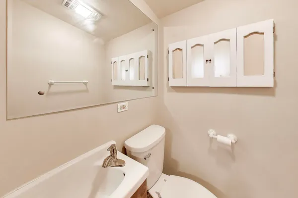 a bathroom with a sink a toilet and mirror