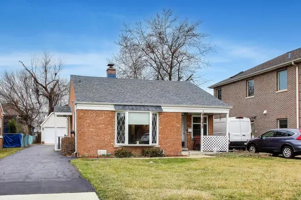 a view of a house with a yard and a large tree
