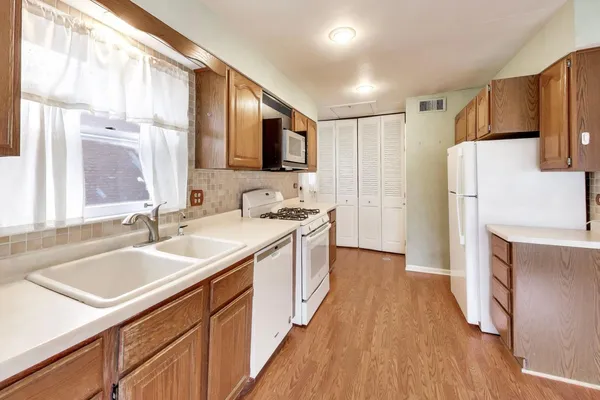 a kitchen with a sink a refrigerator a microwave oven and cabinets