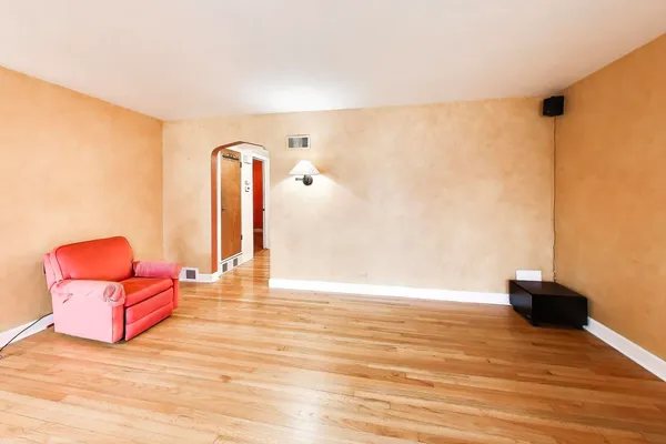 an empty room with wooden floor and glass window