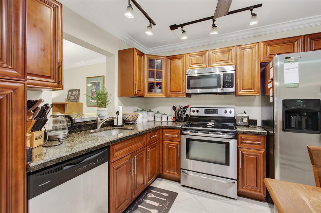 a kitchen with stainless steel appliances granite countertop a stove sink microwave and refrigerator