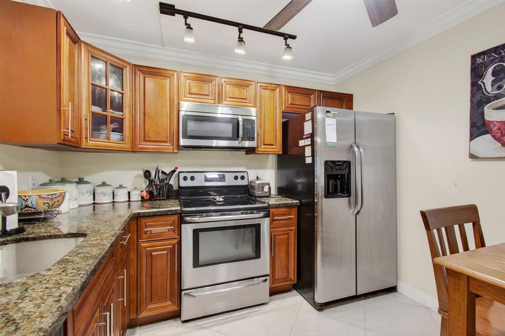 19000 Stewart Circle, Unit 4 Boca Raton, FL 33496 - Photo 11 of 63 a kitchen with stainless steel appliances granite countertop a stove a refrigerator and a microwave