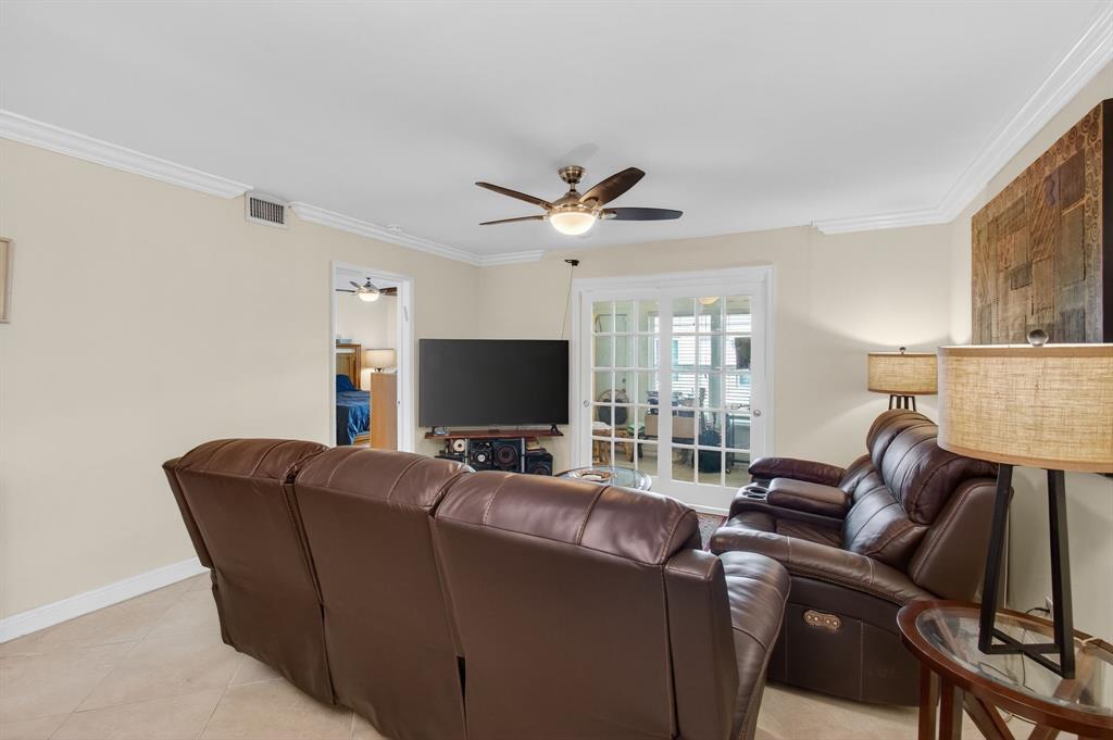 19000 Stewart Circle, Unit 4 Boca Raton, FL 33496 - Photo 18 of 63 a living room with furniture a ceiling fan and a flat screen tv