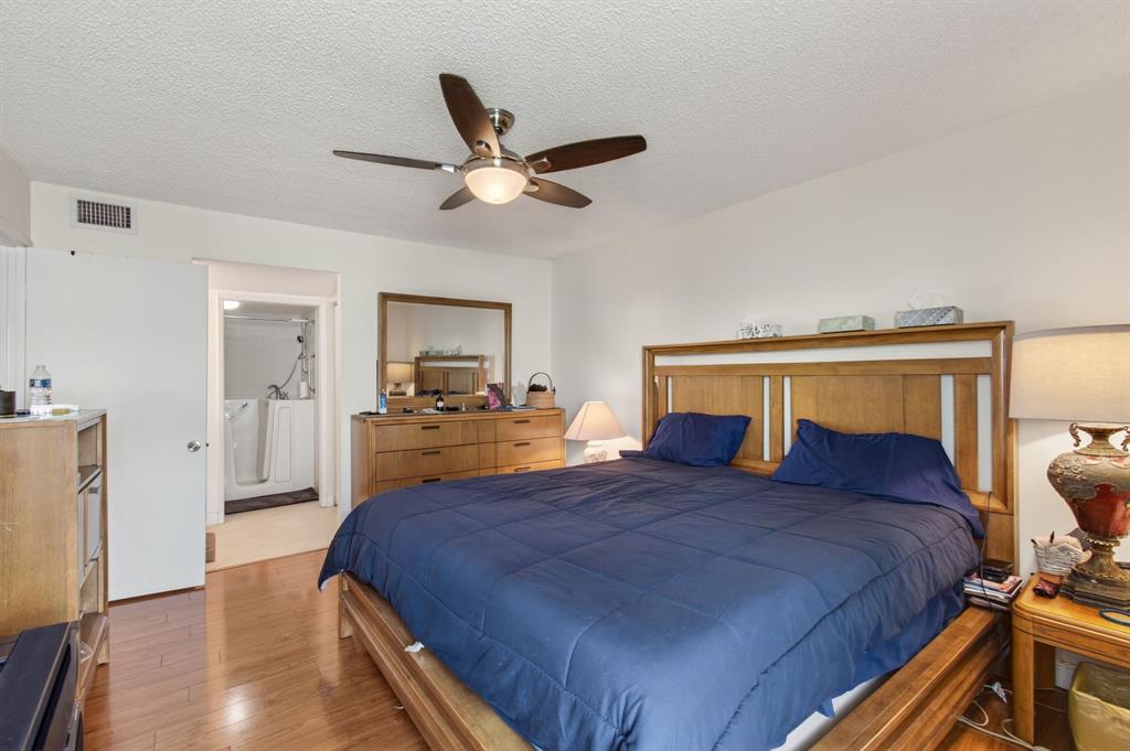 19000 Stewart Circle, Unit 4 Boca Raton, FL 33496 - Photo 32 of 63 a bedroom with a bed and wooden floor