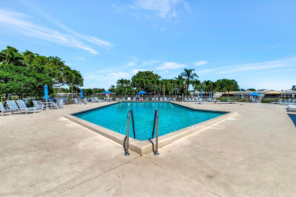 19000 Stewart Circle, Unit 4 Boca Raton, FL 33496 - Photo 60 of 63 a view of a swimming pool with an outdoor seating and a garden
