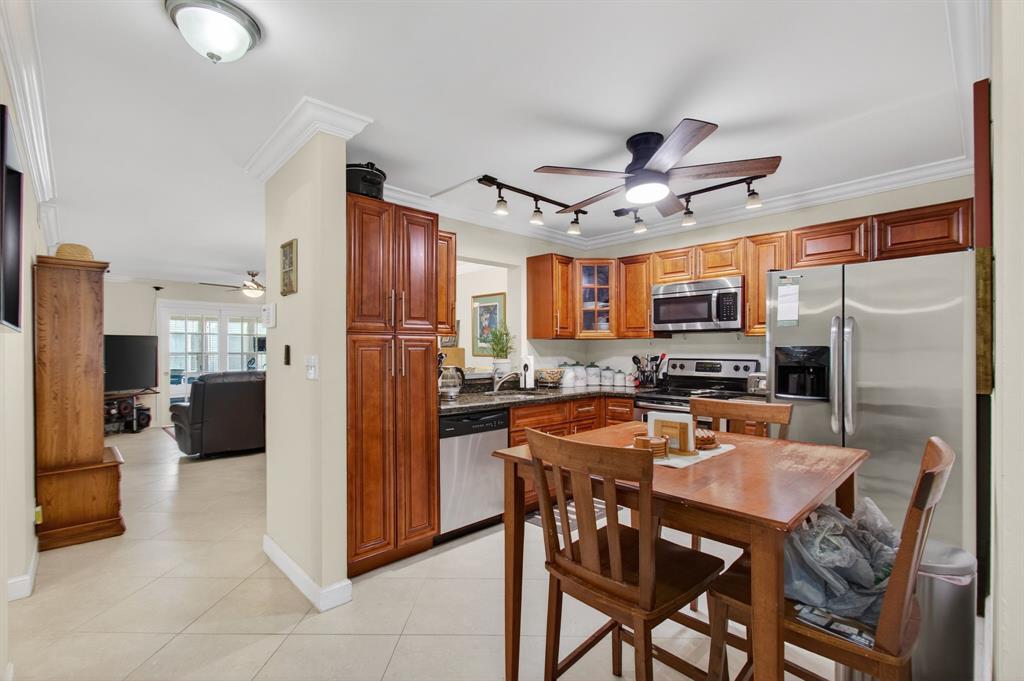 19000 Stewart Circle, Unit 4 Boca Raton, FL 33496 - Photo 8 of 63 a kitchen with stainless steel appliances kitchen island granite countertop a refrigerator and microwave