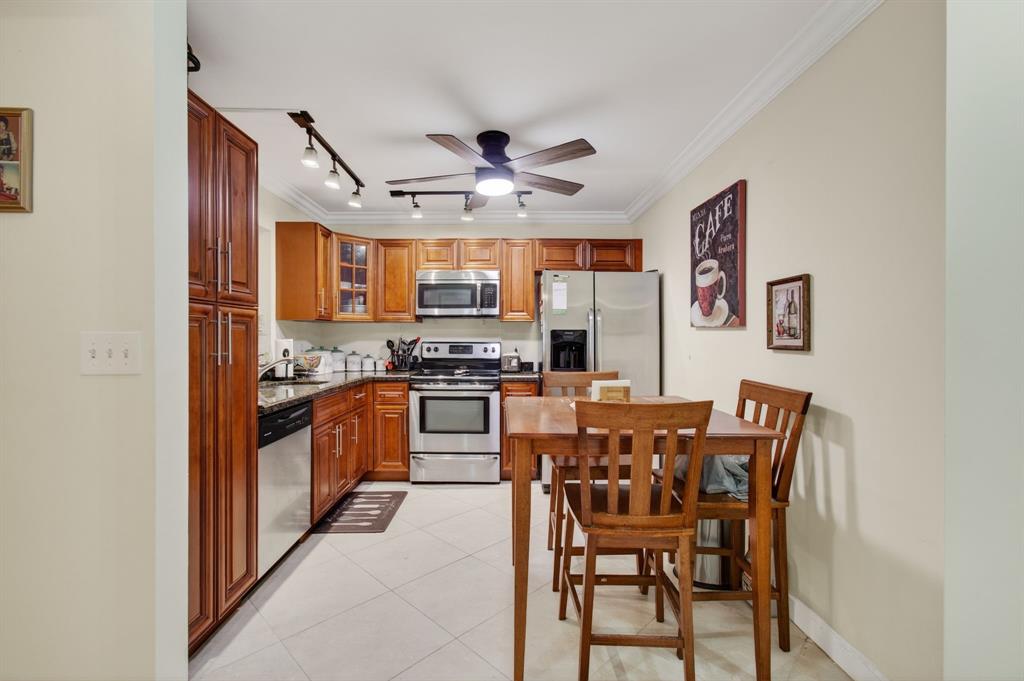 19000 Stewart Circle, Unit 4 Boca Raton, FL 33496 - Photo 9 of 63 a kitchen with stainless steel appliances granite countertop a stove top oven a sink a dining table and chairs