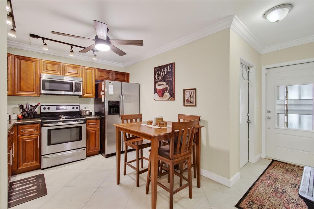 19000 Stewart Circle, Unit 4 Boca Raton, FL 33496 - Photo 10 of 63 a kitchen with stainless steel appliances granite countertop a stove top oven a sink a dining table and chairs with wooden floor