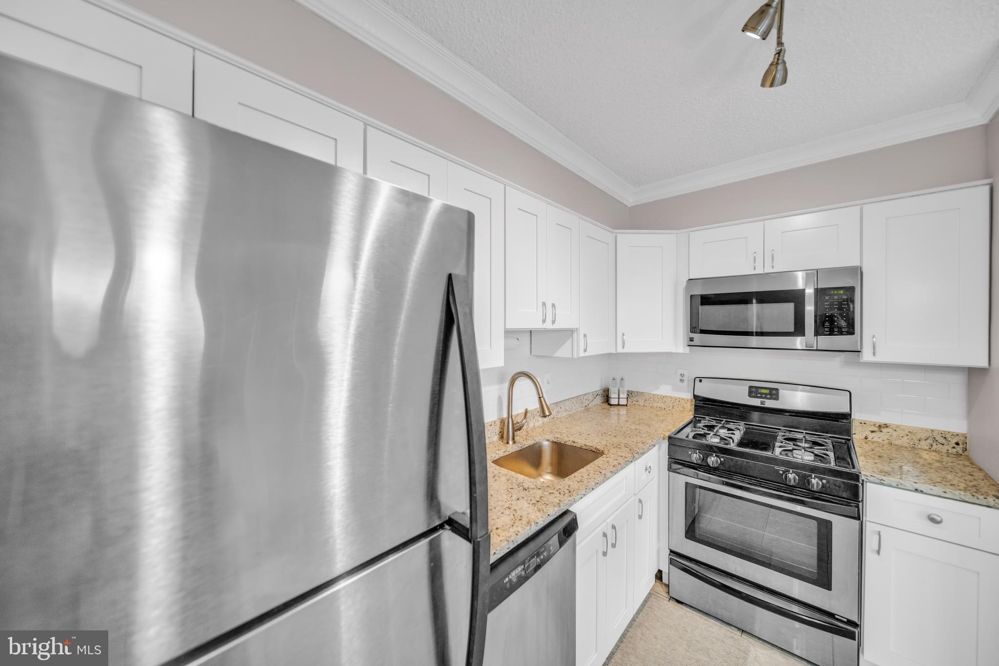 1245 13th Street Northwest, Unit 915 Washington, DC 20005 - Photo 15 of 22 a kitchen with stainless steel appliances granite countertop a refrigerator a stove and a sink with cabinets
