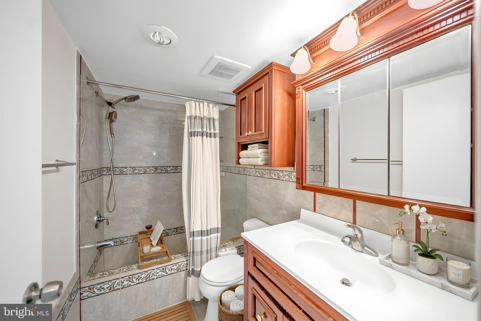 1245 13th Street Northwest, Unit 915 Washington, DC 20005 - Photo 16 of 22 a bathroom with a sink toilet vanity and shower