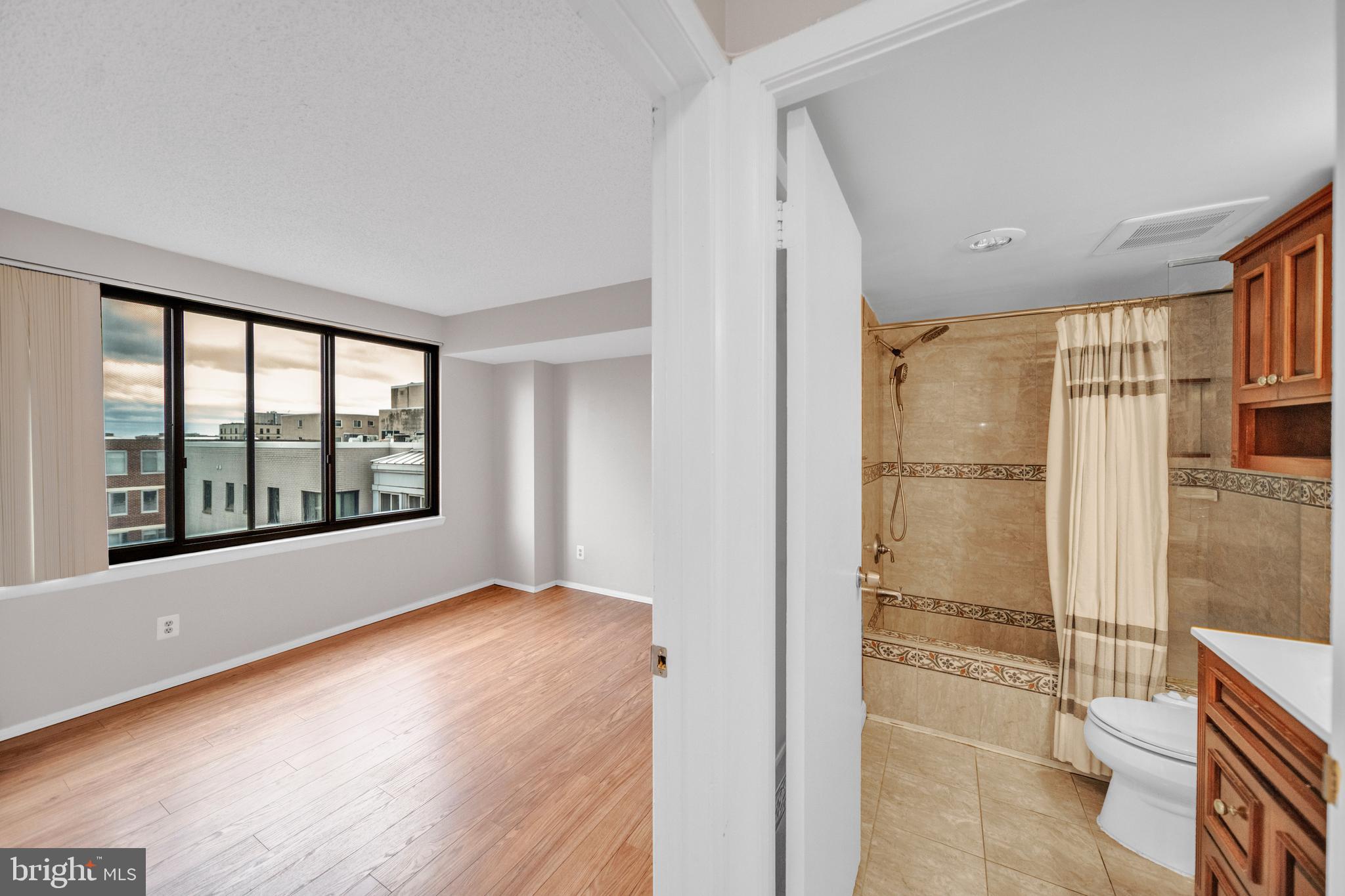 1245 13th Street Northwest, Unit 915 Washington, DC 20005 - Photo 17 of 22 a view of an empty room with glass door and wooden floor