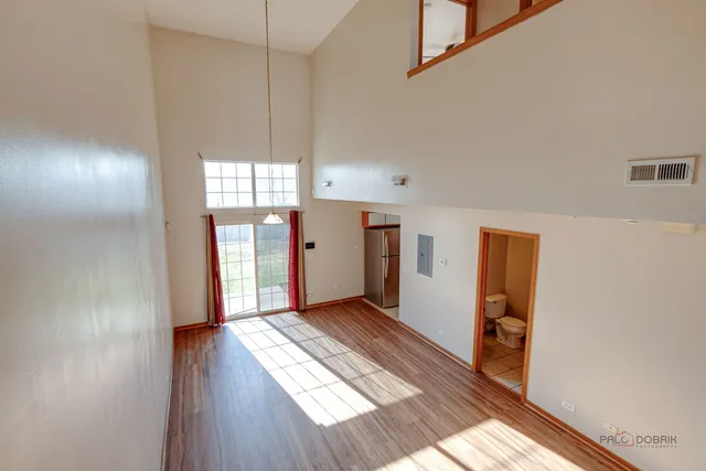 a view of hallway with wooden floor and window
