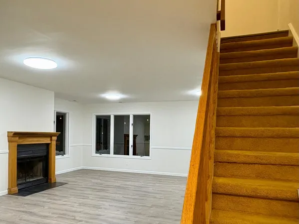 an empty room with wooden floor and fireplace
