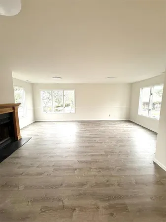 a view of an entryway with wooden floor and a fireplace