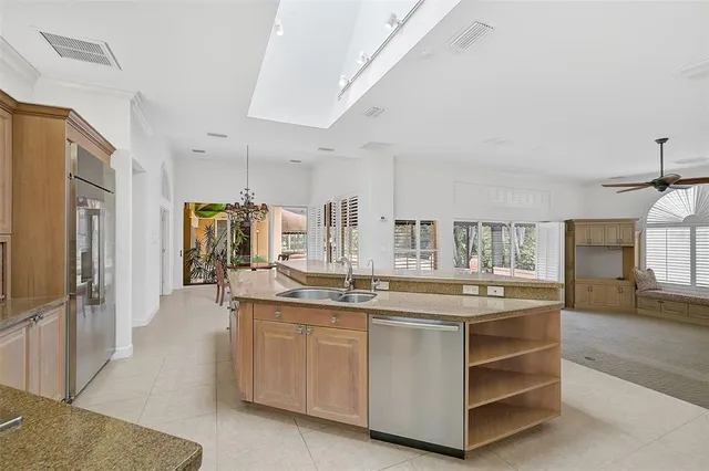 a dining room with furniture a chandelier and a large window
