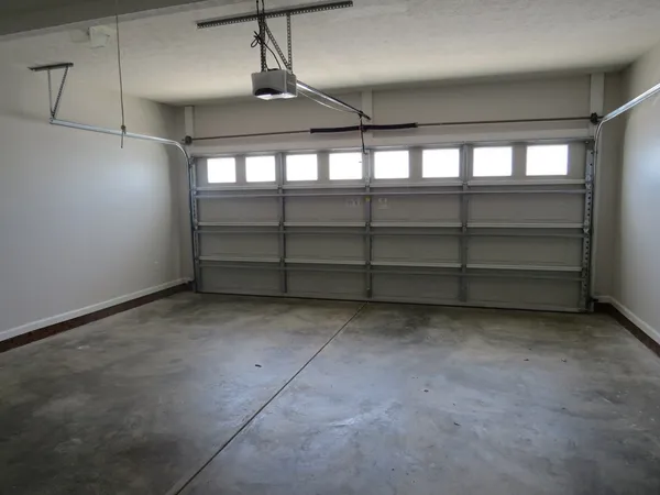 a view of a house with floor to ceiling windows and potted plants