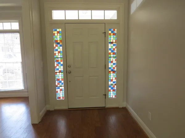 wooden floor fireplace and windows in an empty room