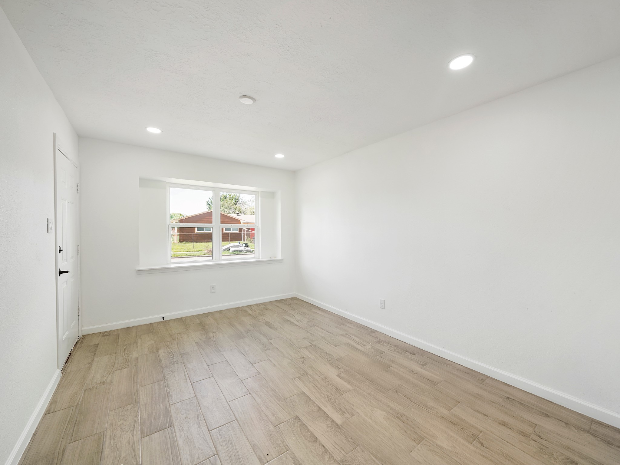 3607 Marchant Road Houston, TX 77047 - Photo 5 of 18 an empty room with a window and wooden floor