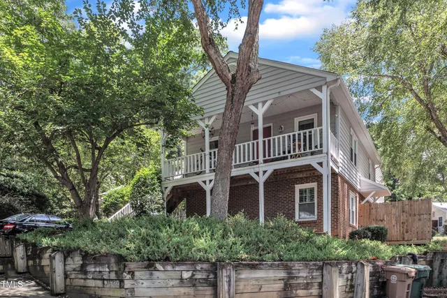 a front view of a house with a tree