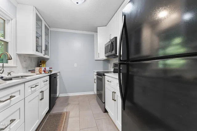 a kitchen with white cabinets and stainless steel appliances