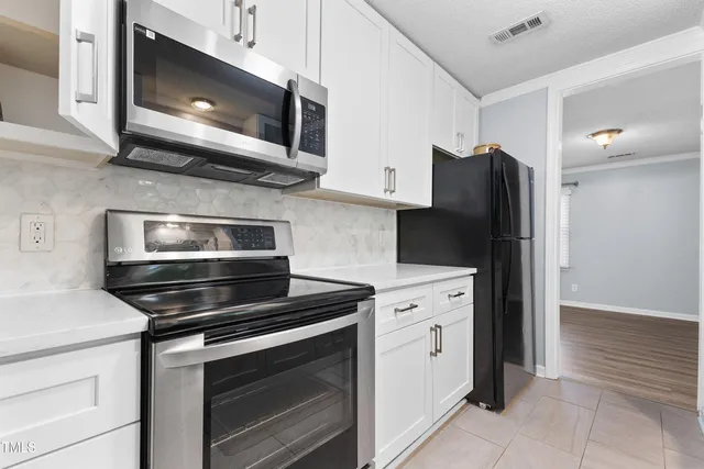 a kitchen with stainless steel appliances a stove microwave and cabinets