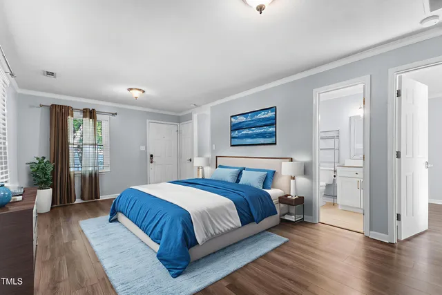 a bedroom with a large bed wooden floor and windows