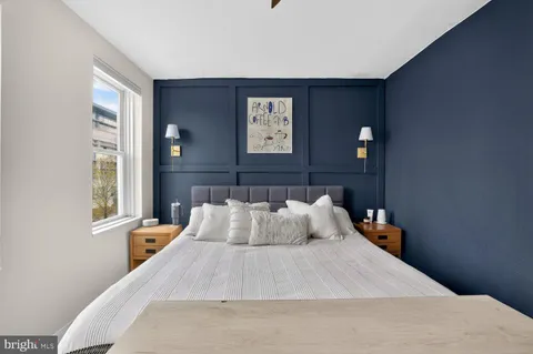 a bedroom with a bed and painting on the wall